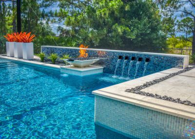 a pool with scuppers and a fire feature in fort myers built by superior pools